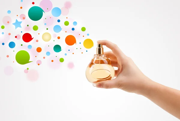 Woman hands spraying colorful bubbles from beautiful perfume bottle — Stock Photo, Image