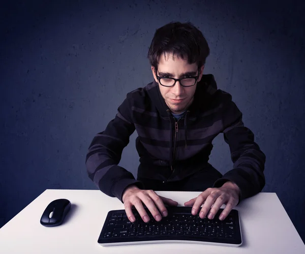 Хакер працює з клавіатурою на синьому фоні. — стокове фото