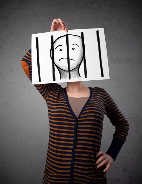 Woman holding a paper with a prisoner behind the bars on it in f — Stock Photo, Image