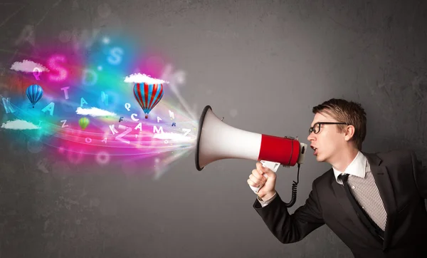 Man shouting into megaphone and abstract text and balloons come — Stock Photo, Image