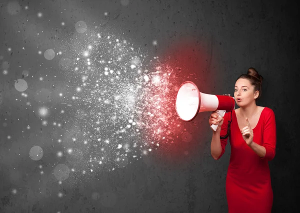 Woman shouting into megaphone and glowing energy particles explo — Stock Photo, Image