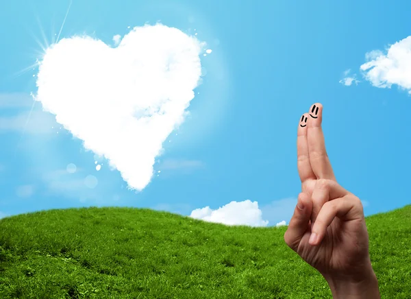 Happy smiley fingers looking at heart shaped cloud — Stock Photo, Image