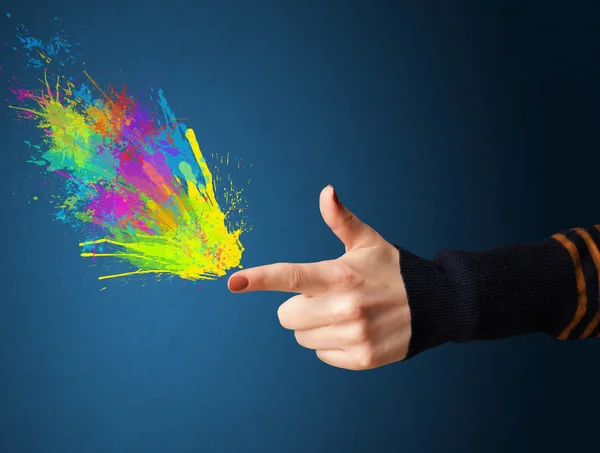 Salpicaduras de colores están saliendo de las manos en forma de pistola —  Fotos de Stock