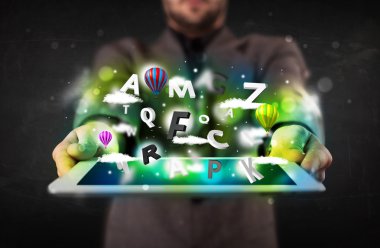 Tableti soyut harflerle ve gökyüzüyle gösteren genç kişi