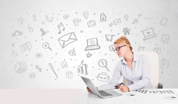 Business woman sitting at table with hand drawn media icons — Stock Photo, Image