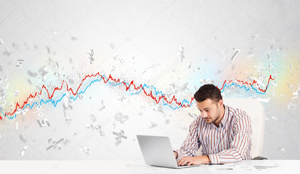 Business man sitting at table with stock market graph 