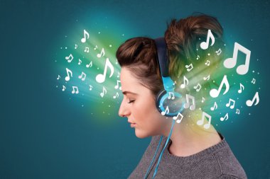 Kulaklıklı genç bir kadın müzik dinliyor.