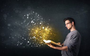 Genç adam sihirli bir kitap okuyor.