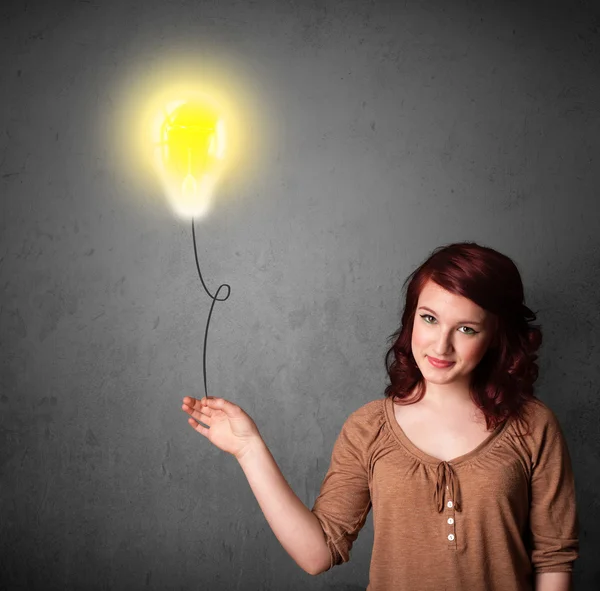 Woman holding a lightbulb balloon — Stock Photo, Image