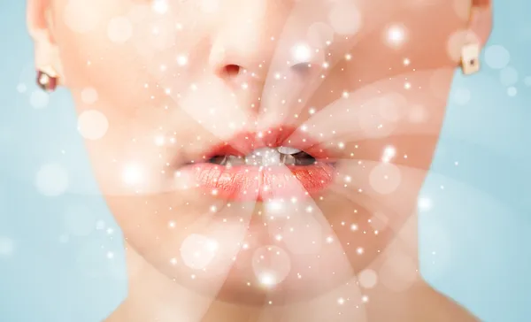 Pretty woman lips blowing abstract white lights — Stock Photo, Image