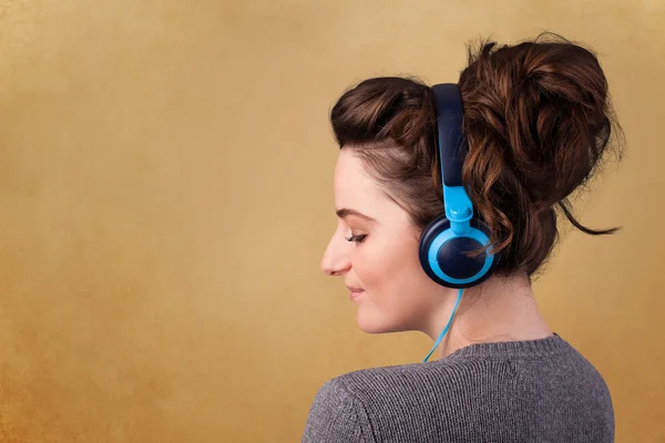 Jeune femme avec écouteurs écoutant de la musique avec espace de copie — Photo