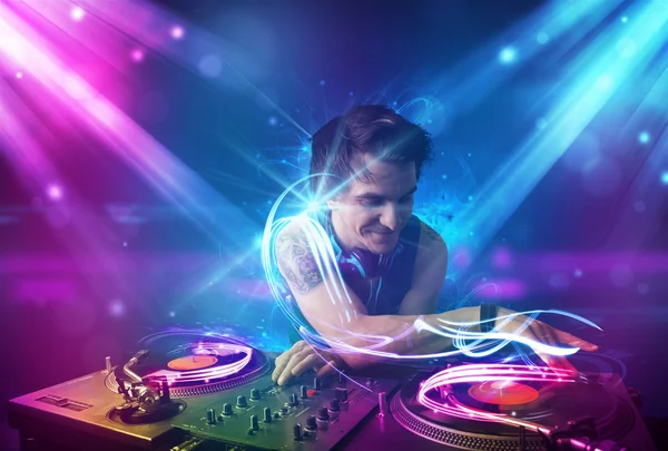 Energiska dj blandande musik med kraftfulla ljuseffekter — Stockfoto