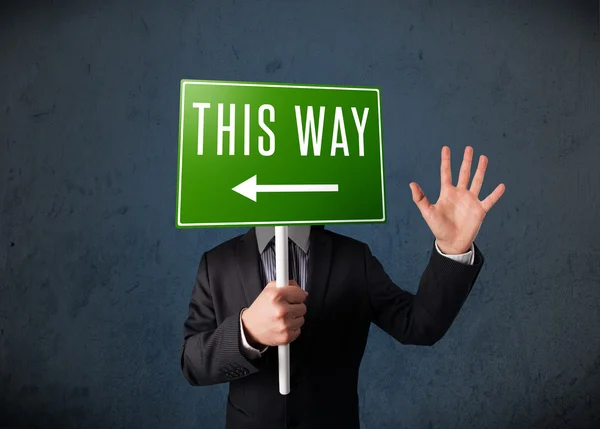 Businessman holding a direction sign — Stock Photo, Image