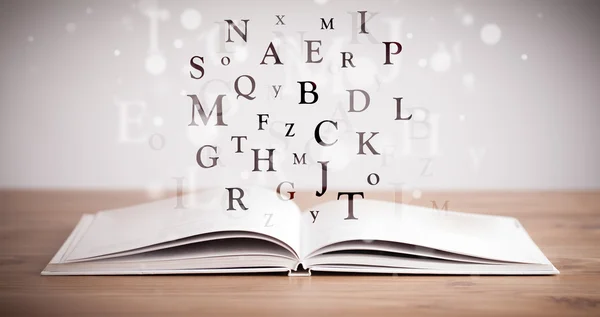 Livre ouvert avec lettres volantes — Photo