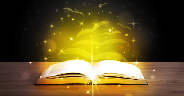 Open book with golden glow flying paper pages — Stock Photo, Image
