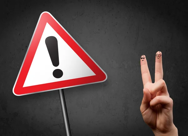 Happy smiley fingers looking at triangle warning sign with excla — Stock Photo, Image