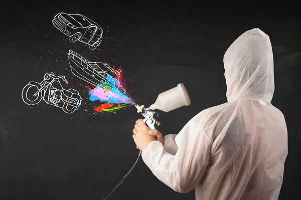 Человек с аэрозольной краской с автомобилем, лодкой и мотоциклом рисовать — стоковое фото