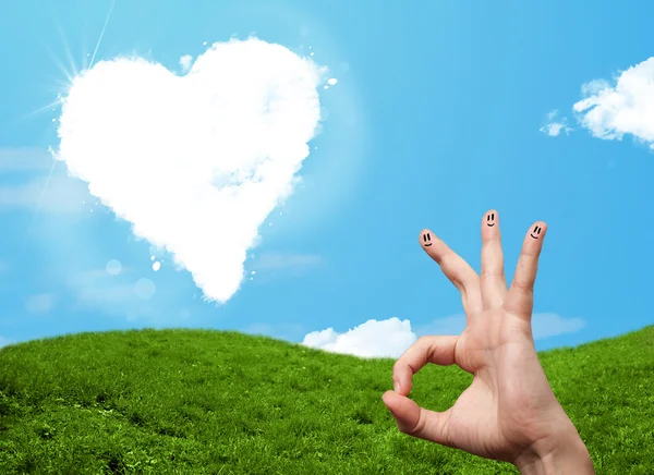 Happy smiley fingers looking at heart shaped cloud — Stock Photo, Image