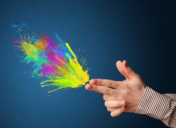 Colorful splashes are coming out of gun shaped hands — Stock Photo, Image