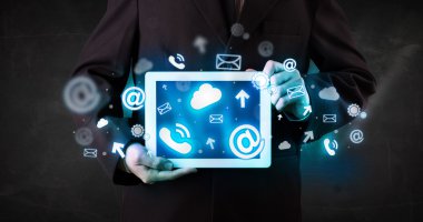 Mavi teknoloji simgeleri ve sembolleri olan bir tablet tutan kişi