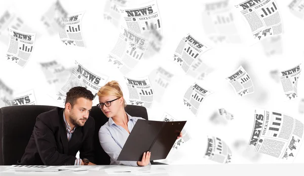 Homme d'affaires et femme au bureau avec des journaux boursiers — Photo