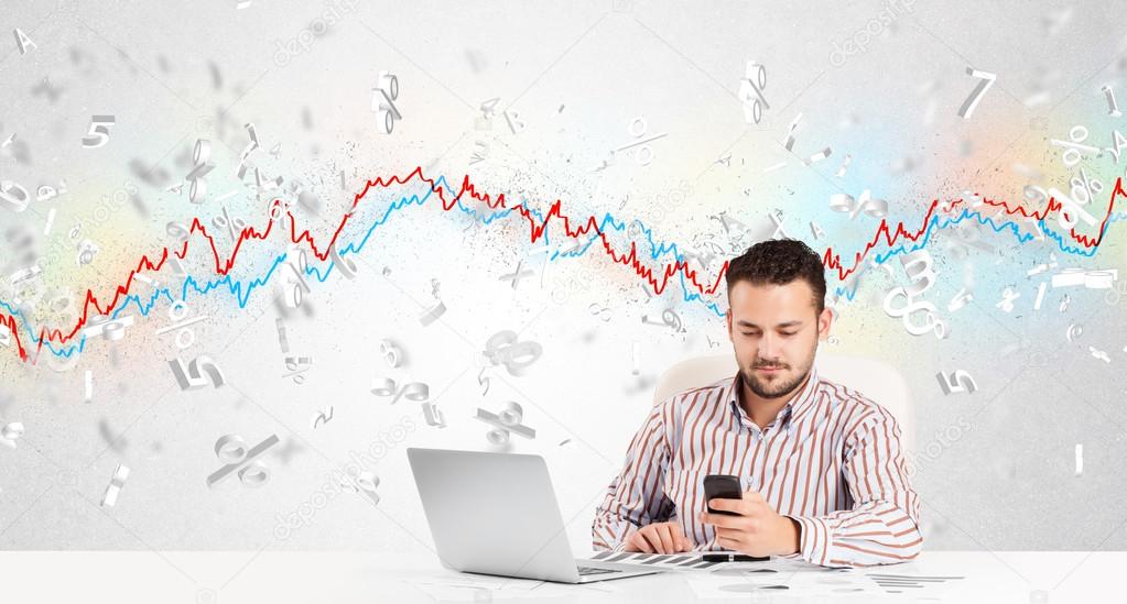 Business man sitting at table with stock market graph 