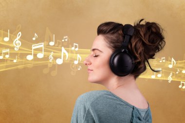Kulaklıklı genç bir kadın müzik dinliyor.
