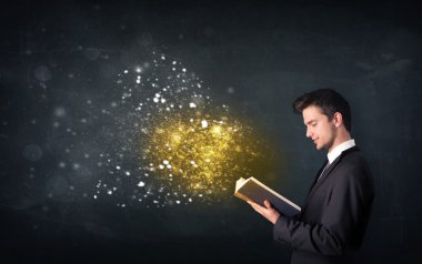 Genç adam sihirli bir kitap okuyor.