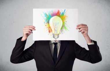 boya sıçraması ve lightbul ile bir karton tutan işadamı
