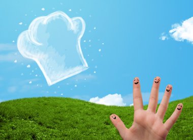 Mutlu gülen yüzlü parmaklar aşçı şapkasının resmine bakıyor.