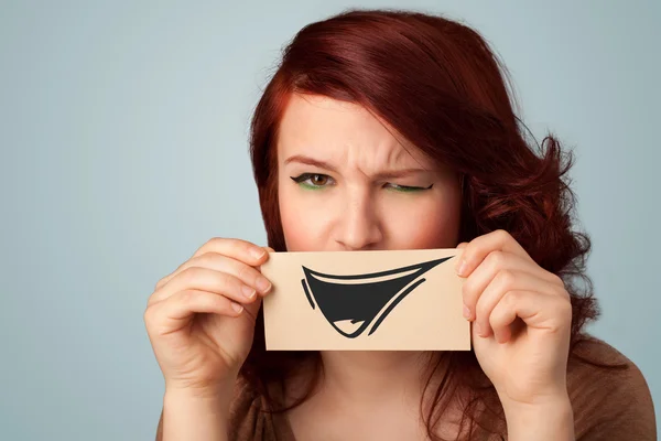 Felice ragazza carina in possesso di carta con divertente disegno smiley — Foto Stock