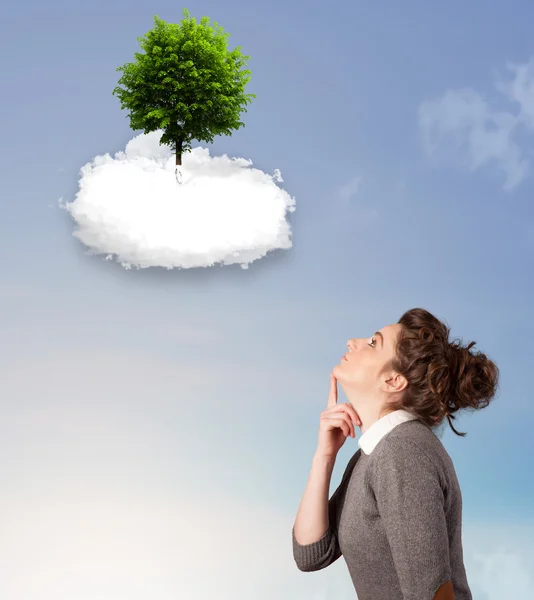 Jong meisje wijzend op een groene boom op de top van een witte wolk — Stockfoto