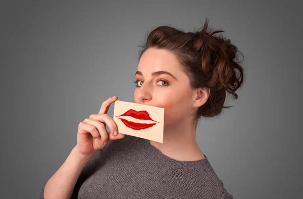 Happy pretty woman holding card with kiss lipstick mark — Stock Photo, Image