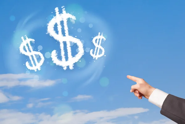 Hand zeigt auf Dollarzeichen Wolken am blauen Himmel — Stockfoto