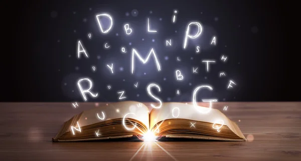 Open book with glowing letters flying out — Stock Photo, Image