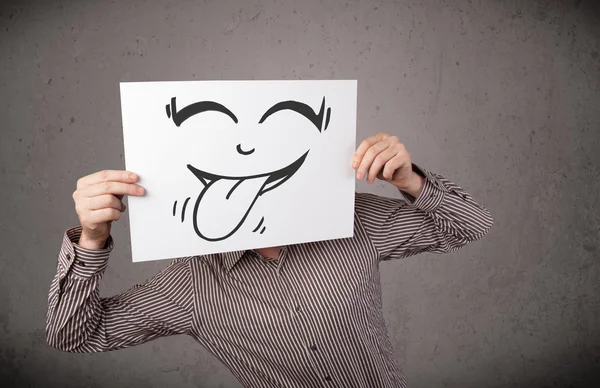 Empresário segurando um papel com cara sorridente engraçado na frente de h — Fotografia de Stock