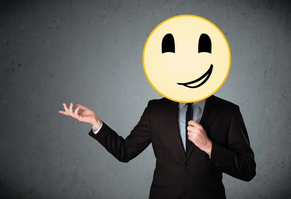 Businessman holding a smiley face emoticon — Stock Photo, Image