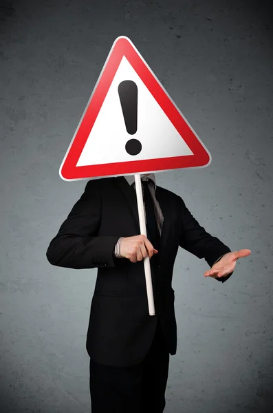 Businessman holding an exclamation road sign — Stock Photo, Image