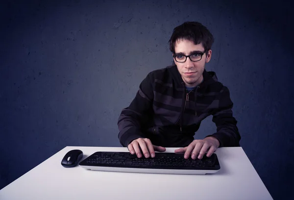 ハッカーは青い背景でキーボードで作業しています — ストック写真