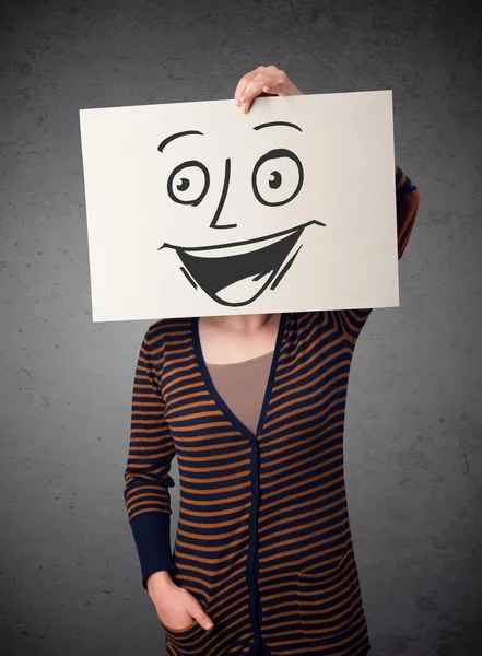 Frau hält einen Karton mit Smiley-Gesicht vor sich — Stockfoto
