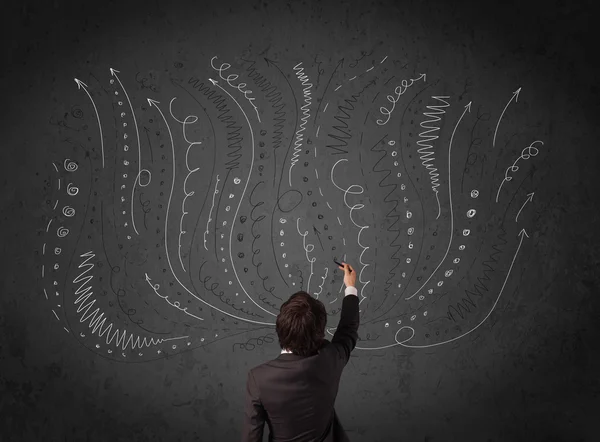 Businessman thinking with sketched arrows in front of a chalkboa — Stock Photo, Image