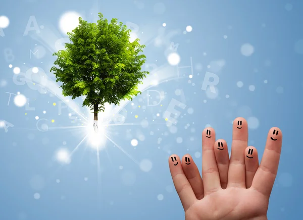 Sorrisos dedo feliz com verde mágico brilhante árvore — Fotografia de Stock