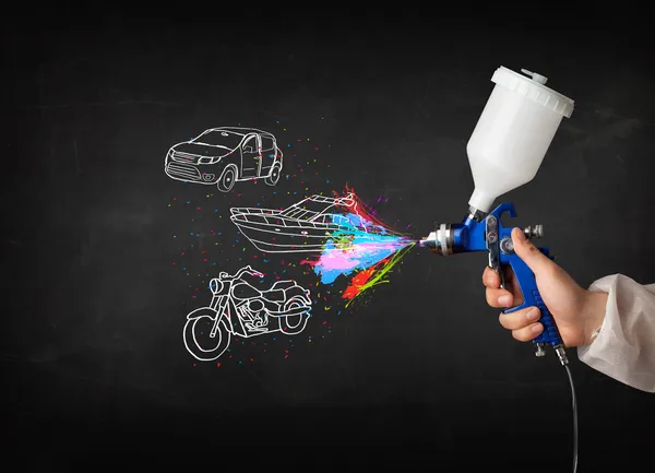 Homme avec peinture aérographe avec dessin de voiture, bateau et moto — Photo