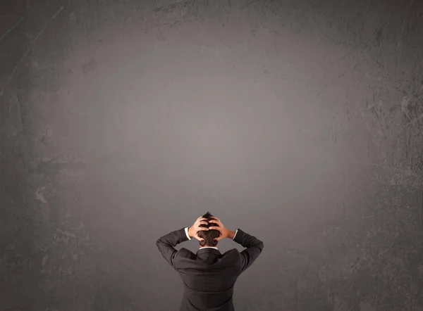 Businessman standing in front of an empty wall — Stock Photo, Image