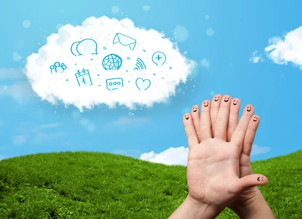Glückliche Smiley-Finger, die auf Wolke mit blauen sozialen Symbolen schauen und — Stockfoto
