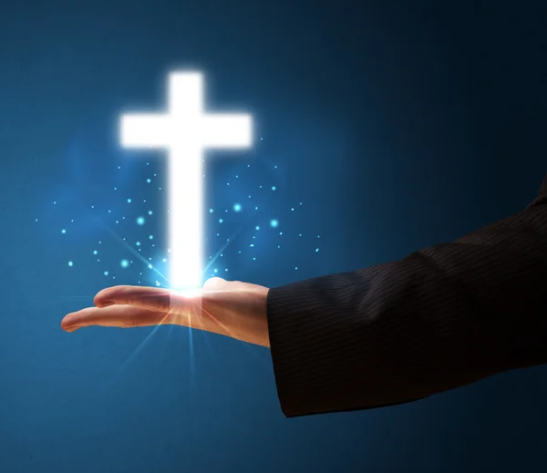 Glowing cross in the hand of a businessman — Stock Photo, Image