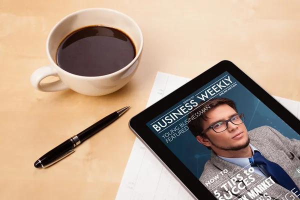 Tablet pc showing magazine on screen with a cup of coffee on a d — Stock Photo, Image