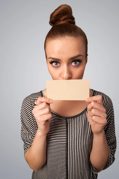 Linda chica sosteniendo la tarjeta blanca en frente de sus labios con spac copia — Foto de Stock