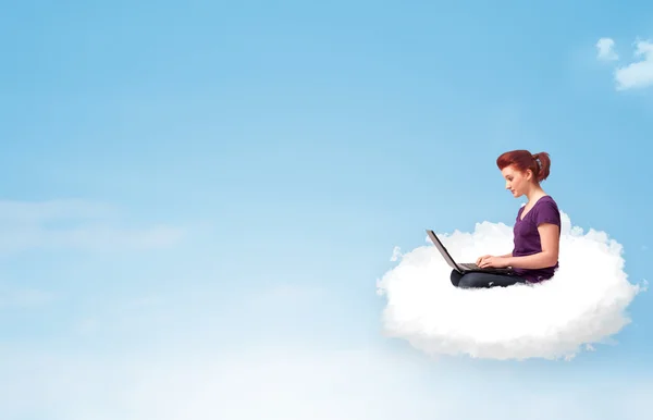 Young woman with laptop sitting on cloud with copy space — Stock Photo, Image