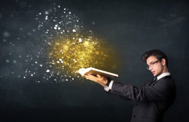 Genç adam sihirli bir kitap okuyor.